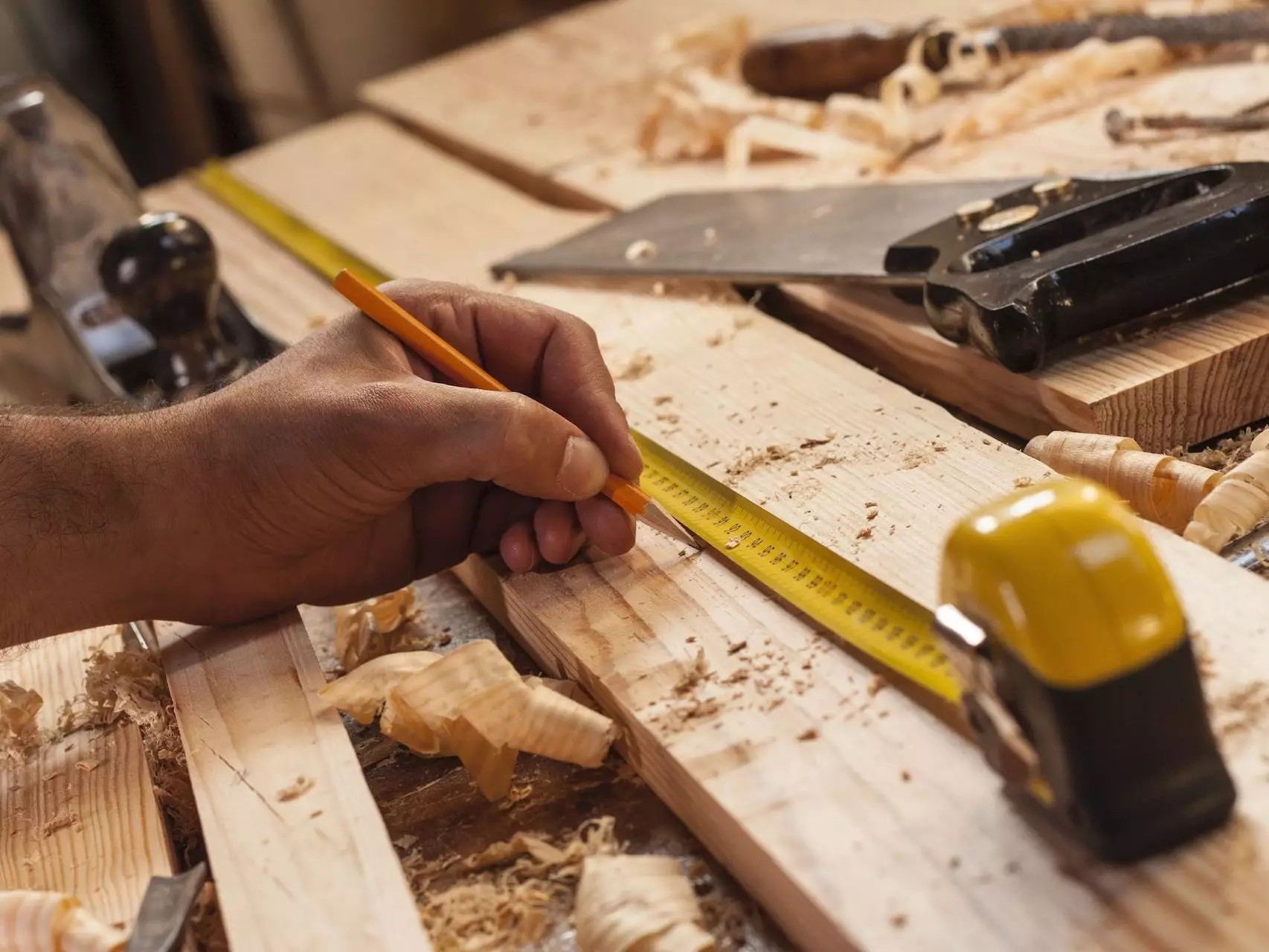 carpenter taking measurement of a wooden plank