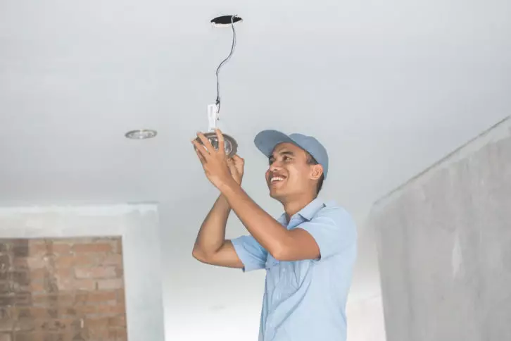 Electrician wiring a ceiling light
